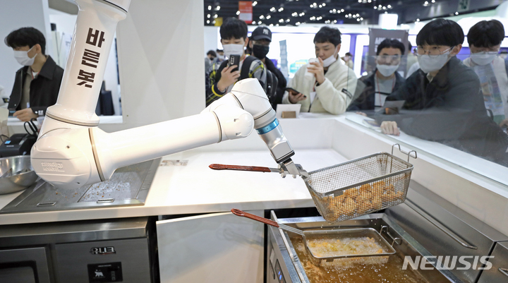 [고양=뉴시스] 김금보 기자 = 26일 경기도 고양시 킨텍스에서 열린 '로보월드 2022'에서 관람객들이 치킨 조리 로봇을 살펴보고 있다. 2022.10.26. kgb@newsis.com