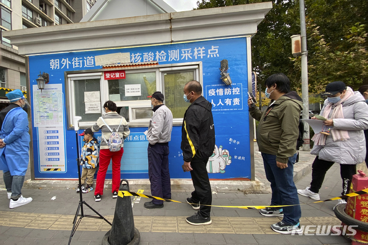 [베이징=AP/뉴시스] 26일 중국 베이징의 한 코로나19 검사소에서 검사를 받으려는 주민들이 줄 서 있다. 중국 당국은 전날 코로나19 확진자가 18명 발생한 후베이성 우한시의 일부 지역을 폐쇄 조치했다. 2022.10.27.