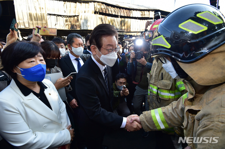 [대구=뉴시스] 이무열 기자 = 이재명 더불어민주당 대표가 28일 오전 대구 북구 대구농수산물도매시장 화재현장을 찾아 소방대원을 격려하고 있다. 2022.10.28. lmy@newsis.com