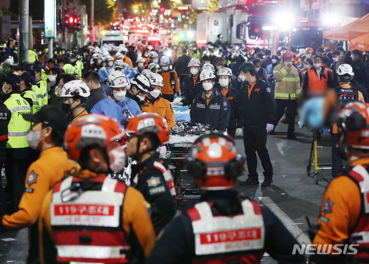 [서울=뉴시스] 김진아 기자 = 2022년 10월 29일 밤 서울 용산구 이태원 일대에서 대규모 압사사고가 발생해 30일 새벽 소방구급 대원들이 사망자를 이송하고 있다. 2022.10.30. bluesoda@newsis.com