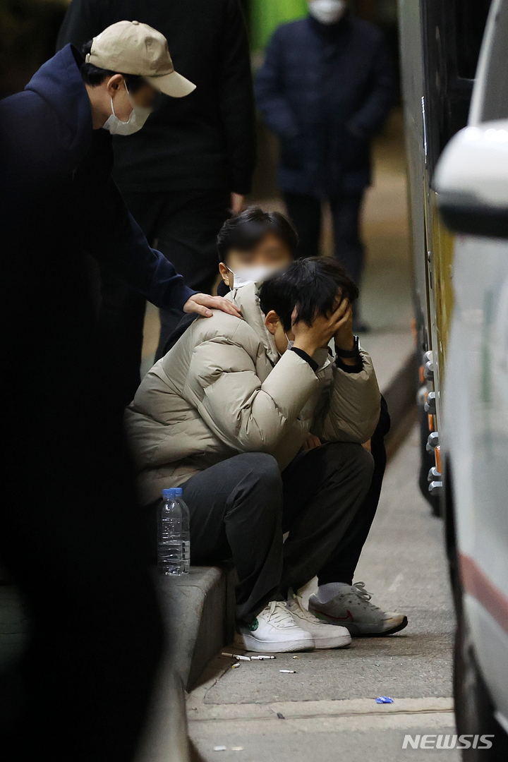 [서울=뉴시스] 백동현 기자 = 지난 29일 밤 서울 용산구 이태원 일대에서 대규모 압사 사고가 발생한 가운데 30일 새벽 원효로 다목적체육관 앞에서 친구와 연락이 두절된 한 시민이 바닥에 앉아 생각에 잠겨 있다. 경찰에 따르면 이날 사망자 중 46구의 시신을 이곳에 안치해둔 상태다. 2022.10.30. livertrent@newsis.com