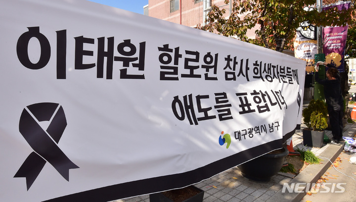 [대구=뉴시스] 이무열 기자 = 이태원 핼러윈 참사와 관련해 2022 대구 할로윈 축제가 전면 취소된 지난 2022년 10월30일 오후 대구 남구 앞산카페거리 공영주차장 할로윈 축제 행사장 인근에 이태원 핼러윈 참사 희생자를 애도하는 현수막이 설치되고 있는 모습. 2022.10.30. lmy@newsis.com