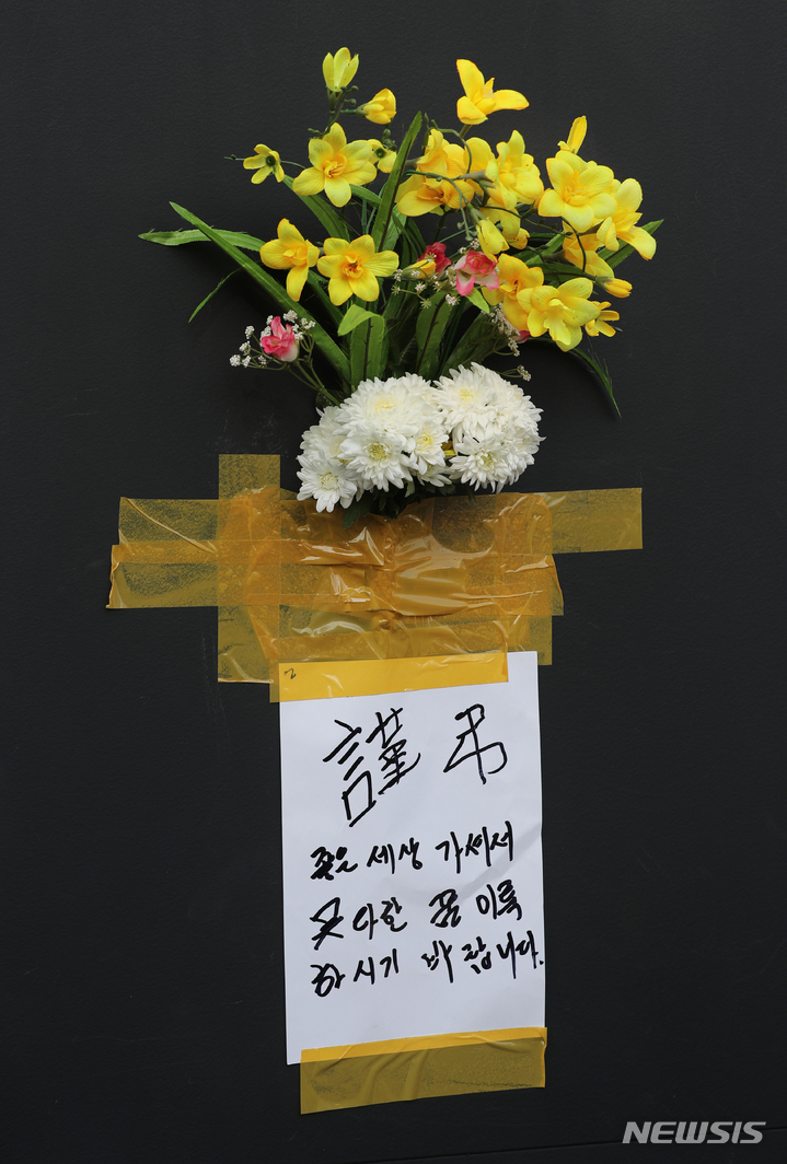 [서울=뉴시스] 김금보 기자 = 30일 오후 서울 용산구 이태원 할로윈 참사 현장 인근 건물 외벽에 한 시민이 근조화를 부착하고 애도하고 있다. 2022.10.25. kgb@newsis.com