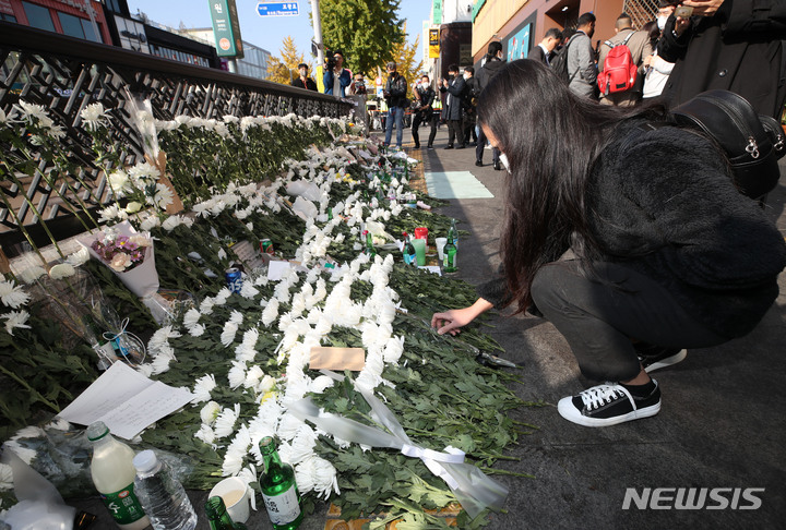 [서울=뉴시스] 조수정 기자 = 지난달 31일 오전 서울 용산구 이태원 압사 참사 현장 인근인 이태원역 1번출구 앞 희생자 추모공간에서 한 시민이 헌화하고 있다. 2022.10.31. chocrystal@newsis.com