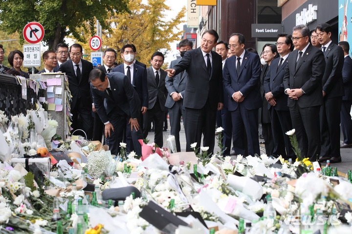 [서울=뉴시스] 전신 기자 = 윤석열 대통령이 1일 서울 용산구 이태원역 1번 출구 앞에 마련된 '이태원 압사 참사' 희생자 추모 공간을 찾아 헌화한 후 추경호 경제부총리와 대화하고 있다. 2022.11.01. photo1006@newsis.com