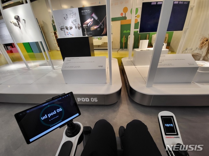 [서울=뉴시스]KT '자율주행 스마트로봇체어'에 탑승해 실제로 동대문디자인플라자(DDP)의 전시를 관람하는 가운데 스마트로봇체어가 전시물 앞에서 일시정지해있다. 로봇 좌측에 달린 스크린에서는 현재 관람 중인 전시물의 종류가 나타나있으며, 향후 소프트웨어 업그레이드를 통해 도슨트의 설명 및 전시장 지도 등까지도 표출될 예정이다. (사진=윤현성 기자)