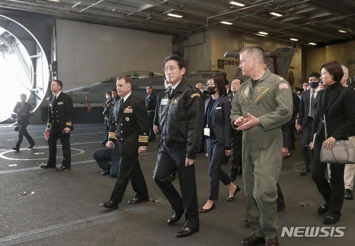 [사가미=AP/뉴시스]기시다 후미오 일본 총리(가운데)가 지난 6일 가나가와현 사가미만에서 열린 국제관함식에 참석했다. 미군의 항모 로널드 레이건호를 방문해 관계자에게 설명을 듣고 있다. 2022.11.07.