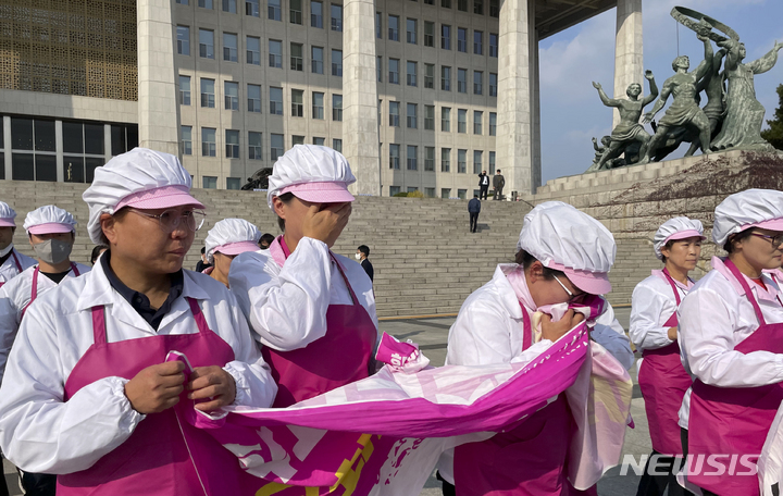 [서울=뉴시스] 최진석 기자 = 학교급식실 노동자들이 8일 오후 서울 여의도 국회의사당 앞에서 학교급식실 인력충원 국회 예산 편성 촉구 및 학교급식실 폐암환자 속출 대책 마련 촉구 기자회견을 마친 뒤 눈물을 훔치며 이동하고 있다. 2022.11.08. myjs@newsis.com