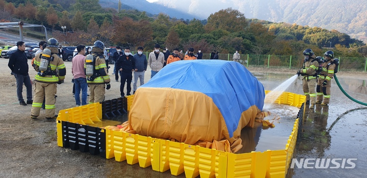 [창원=뉴시스] 홍정명 기자= 경남도소방본부 '이동식 침수조'를 활용한 전기차 화재 진압 시연.(사진=경남소방 제공)2022.11.09. photo@newsis.com