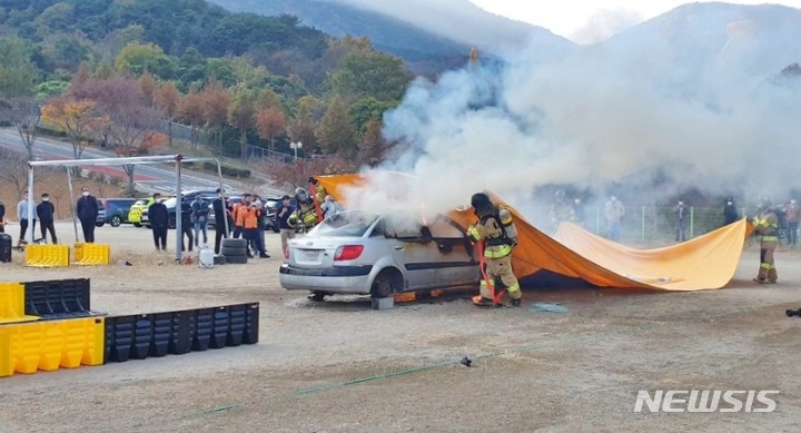 [창원=뉴시스] 홍정명 기자= 경남도소방본부 '질식소화덮개'를 활용한 전기차 화재진압 시연.(사진=경남소방 제공)2022.11.09.  photo@newsis.com