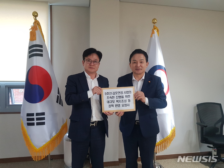 [김포=뉴시스]김병수 김포시장이 원희룡 국토부 장관에게 대규모 택지 개발 건의서를 전달하고 있다.