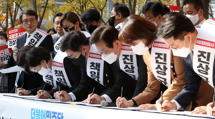 [서울=뉴시스] 지난 11일 더불어민주당 의원들이 서울 여의도역 인근에서 열린 이태원참사 국정조사·특검 추진 범국민 서명운동 발대식에서 서명하고 있다. 2022.11.11 amin2@newsis.com