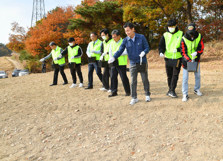 [울산=뉴시스]김영길 울산 중구청장과 전호환 동명대학교 총장 일행이 지난 11일 중구 다운목장 부지를 방문해 꽃양귀비와 안개초 씨앗을 뿌리고 있다. (사진=울산 중구 제공) photo@newsis.com *재판매 및 DB 금지