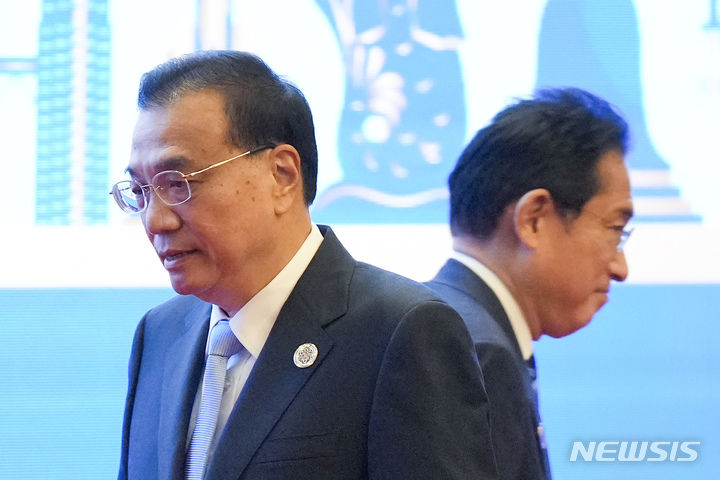 [프놈펜=AP/뉴시스]리커창 중국 총리(사진 왼쪽)가 12일 캄보디아 프놈펜에서 열린 아세안(ASEAN)+3 정상회의 단체사진을 찍은 후 기시다 후미오 일본 총리 옆을 지나가고 있다. 2022.11.12.