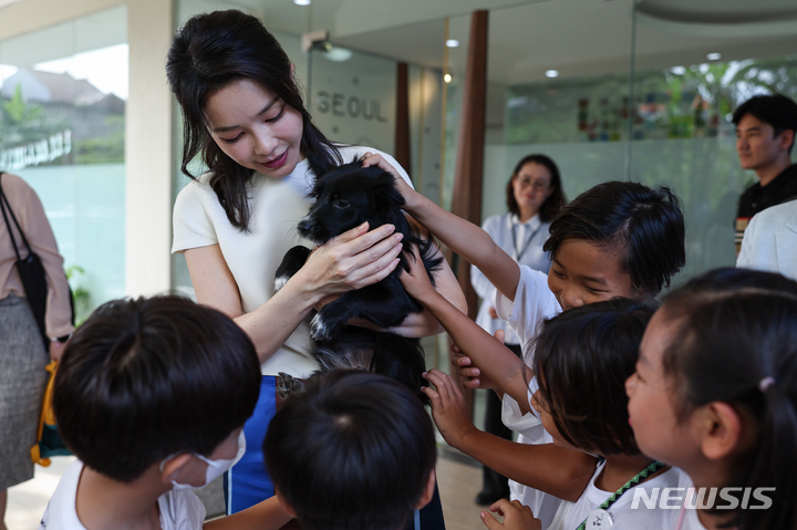 [발리=뉴시스] 홍효식 기자 = 윤석열 대통령 부인 김건희 여사가 지난 14일(현지시간) 발리 교민 자녀와 현지 학생 및 청년에게 한글 교육 및 문화를 전파하는 한국 학교를 방문해 강아지를 만지고 있다. (사진=대통령실 제공) 2022.11.15. photo@newsis.com