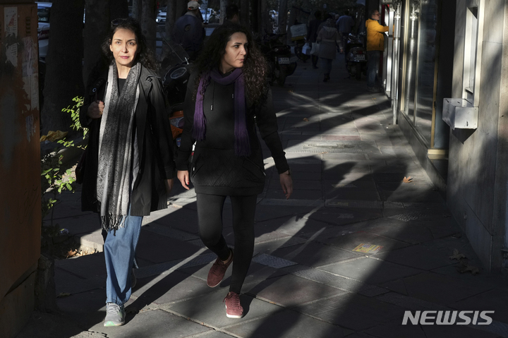 [테헤란=AP/뉴시스] 히잡을 쓰지 않은 이란 여성들이 14일(현지시간) 테헤란 거리를 다니고 있다. 히잡을 제대로 쓰지 않았다는 이유로 경찰에 체포돼 의문사한 마흐사 아미니 사건 이후 이란 전역에서 반정부 시위가 이어지고 있다. 2022.11.15.