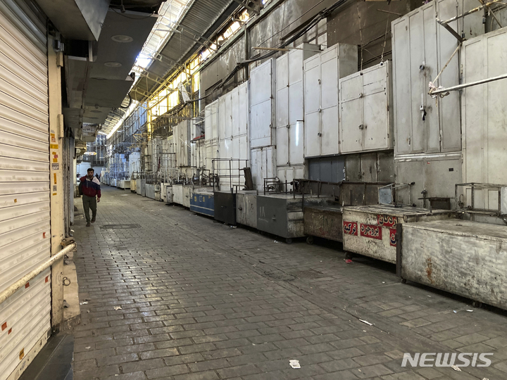 [테헤란=AP/뉴시스]한 남자가 15일(현지시간) 이란 테헤란 그랜드 바자에 폐쇄된 상점들 사이로 걸어가고 있다. 이란에는 지난 9월 히잡을 착용하지 않은 여대생이 종교 경찰에 구금된 뒤 숨진 사건이 벌어졌다. 이후 전역에 반정부 시위가 계속되고 있다. 2022.11.16