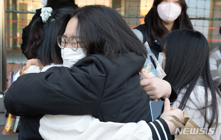 [울산=뉴시스] 배병수 기자 = 2023학년도 대학수학능력시험을 하루 앞둔 16일 오전 울산 남구 강남고등학교를 찾은 수험생들이 수험표를 받은 뒤 친구와 포옹을 하고 있다. 2022.11.16. bbs@newsis.com