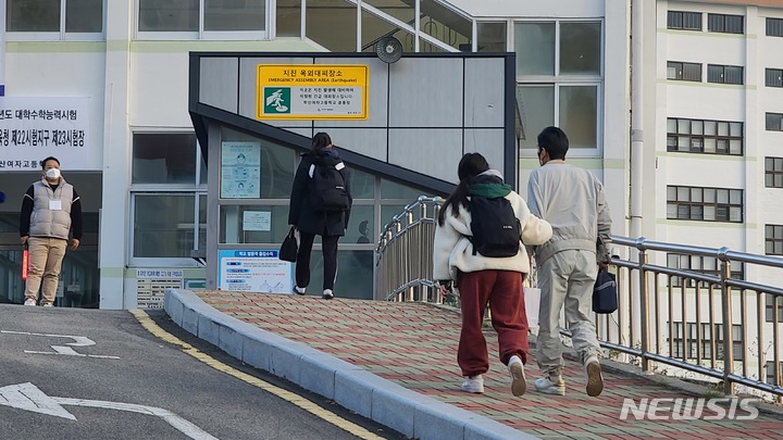 [부산=뉴시스] 권태완 기자 = 2023학년도 대학수학능력시험일인 17일 오전 부산 동래구의 한 고사장에서 한 학부모가 수험생인 딸의 손을 잡고 입구까지 배웅하고 있다. 2022.11.17. kwon97@newsis.com