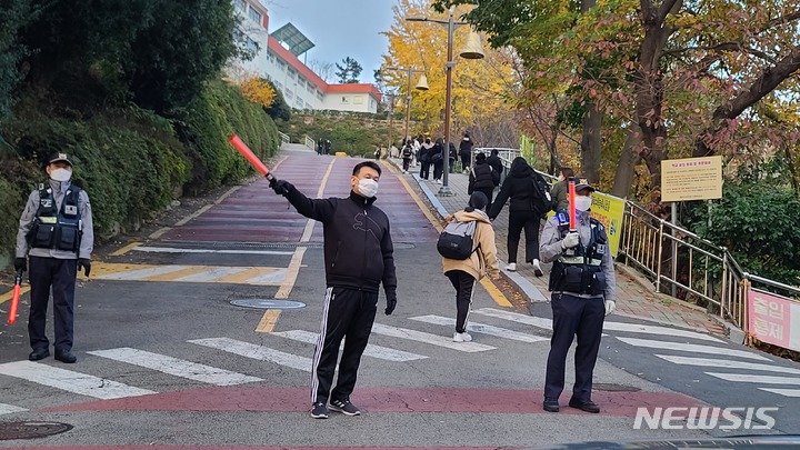 [부산=뉴시스] 권태완 기자 =2023학년도 대학수학능력시험일인 17일 오전 부산 동래구의 한 시험장 앞에서 경찰과 교육청 직원이 교통정리를 하고 있다. 2022.11.17. kwon97@newsis.com 