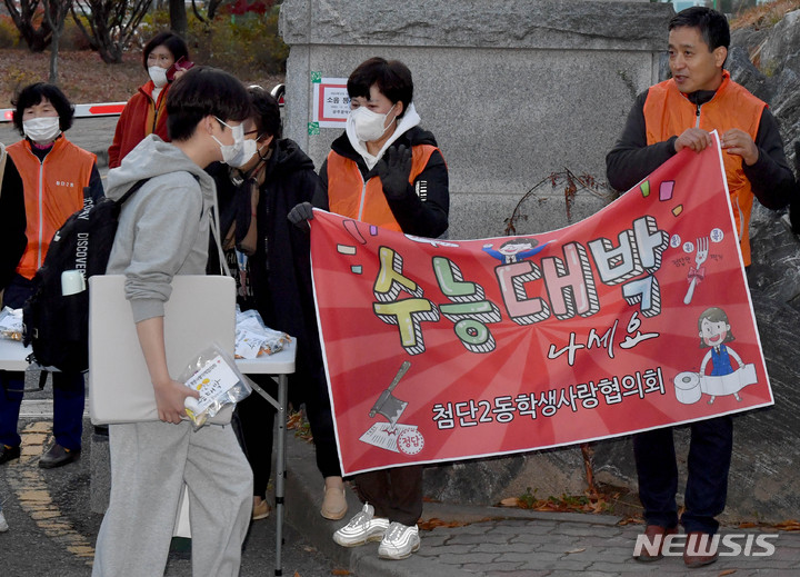 [광주=뉴시스] 변재훈 기자 = 2023학년도 대학수학능력시험일인 17일 오전 광주 광산구 26지구 11시험장(첨단고등학교) 앞에서 수험생들이 주민자생단체 응원을 받으며 시험장으로 향하고 있다. 2022.11.17. wisdom21@newsis.com