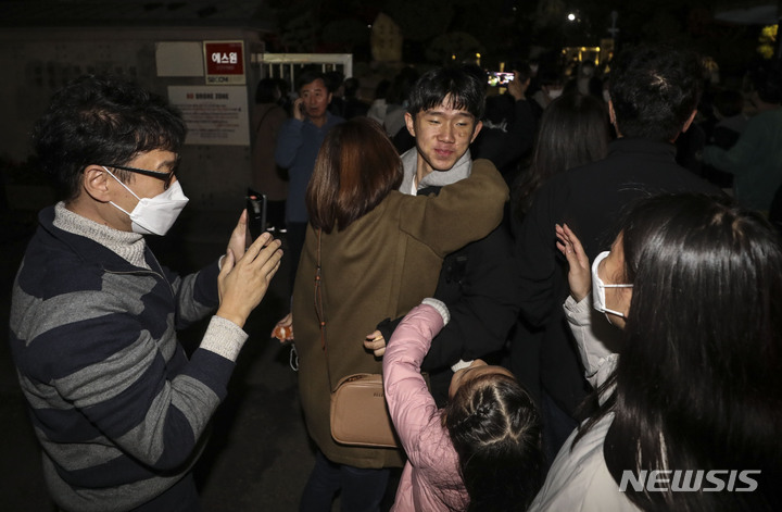 [서울=뉴시스] 김근수 기자 = 2023학년도 대학수학능력시험일인 17일 오후 서울 종로구 경복고등학교에서 시험을 마친 한 수험생이 가족과 인사를 나누고 있다. 2022.11.17. ks@newsis.com