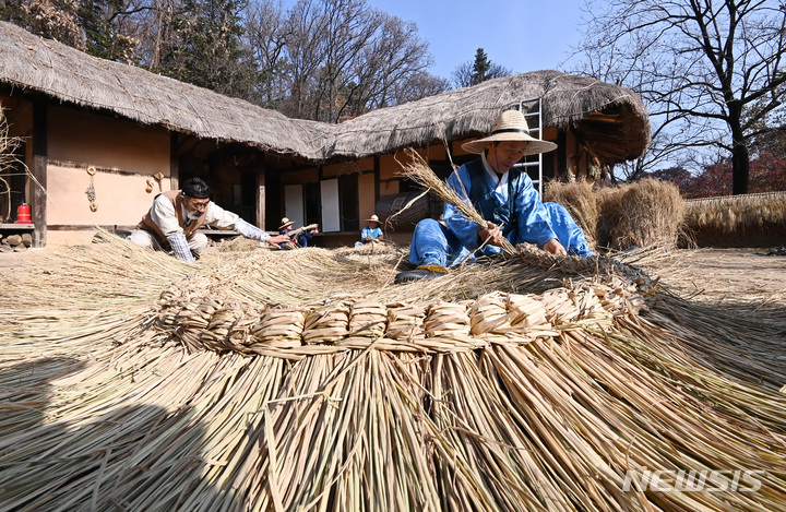 [용인=뉴시스] 김종택 기자 = 절기상 소설(小雪)을 하루 앞둔 21일 오전 경기도 용인 한국민속촌에서 관계자들이 초가지붕에 올릴 용마름과 이엉 잇기 작업을 하며 겨울을 준비하고 있다. 2022.11.21. jtk@newsis.com