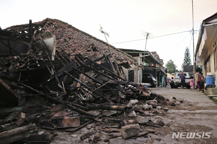 [치안주르=AP/뉴시스] 21일(현지시간) 인도네시아 서자바주 키안주르에서 규모 5.6의 지진이 발생한 후 주민들이 무너진 집 앞을 지나고 있다. 현지 당국은 이번 지진으로 지금까지 최소 162명이 숨졌다고 밝혔으며 사망자 수는 더 늘어날 것으로 보인다. 2022.11.22.