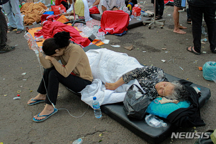 [치안주르=AP/뉴시스] 21일(현지시간) 인도네시아 서자바주 치안주르에서 규모 5.6의 지진이 발생해 생존자들이 한 병원 밖에서 치료받고 있다. 현지 당국은 이번 지진으로 지금까지 최소 162명이 숨졌다고 밝혔으며 사망자 수는 더 늘어날 것으로 보인다. 2022.11.22. 