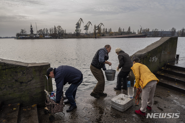 [헤르손=AP/뉴시스] 우크라이나 헤르손 주민들이 드네프르강에서 물을 긷고 있다. 