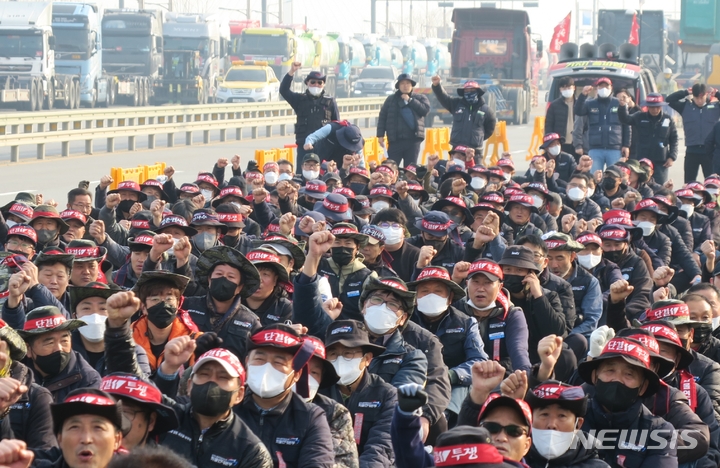 [인천=뉴시스] 김동영 기자 = 민주노총 공공운수노조 화물연대본부가 안전 운임 일몰제 폐지를 요구하며 총파업에 돌입한 24일 오전 인천 연수구 인천 신항 컨테이너 터미널 앞에서 인천지역본부 조합원들이 출정식을 열고 구호를 외치고 있다. 2022.11.24. dy0121@newsis.com 