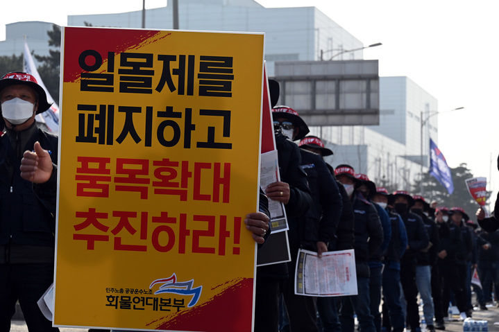 [서울=뉴시스] 민주노총 공공운수노조 화물연대 충남지역본부 소속 조합원이 24일 당진시 송악읍 현대제철 정문 앞에서 일몰제 폐지와 차종·품목 확대를 요구하는 팻말을 들고 있다. (사진= 민주노총 공공운수노조 화물연대 제공) 2022.11.24 photo@newsis.com  *재판매 및 DB 금지