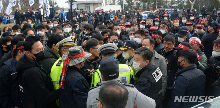 [군산=뉴시스] 김얼 기자 = 전북 군산시 군산항 5부두 앞에서 민주노총 공공운수노조 화물연대 전북지역본부 총파업 출정식이 열린 24일 경찰과 민주노총 관계자들이 복잡하게 뒤엉켜 있다. 이 충돌은 경찰이 트럭 짐칸에 노조원들을 태워 이동한 운전자에게 도로교통법 위반 사항으로 범칙금을 부과하다가 발생했다. 2022.11.24. pmkeul@newsis.com