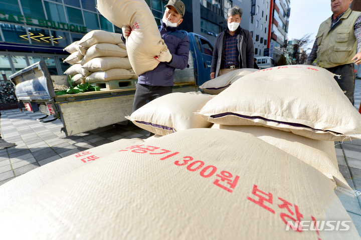 [광주=뉴시스] 김혜인 기자 = 전국농민회총연맹 광주시 농민회가 국민의힘 광주시당 앞에서 '쌀값 폭락에 따른 윤석열 정부 규탄'기자회견을 열고 쌀값 안정화 문구가 적힌 쌀포대를 옮기고 있다. 2022.11.24.hyein0342@newsis.com