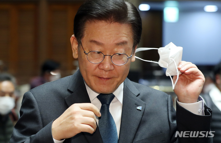 [서울=뉴시스] 최진석 기자 = 이재명 더불어민주당 대표가 24일 서울 여의도 국회에서 열린 의원총회에 참석해 발언대로 이동하며 마스크를 벗고 있다. 2022.11.24. myjs@newsis.com