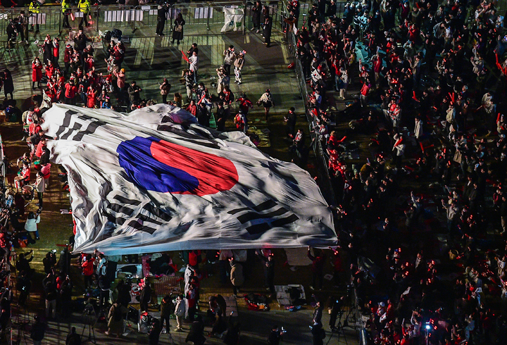 [서울=뉴시스] 배훈식 기자 = 지난 24일 오후 서울 종로구 광화문 광장에서 붉은 악마 응원단과 시민들이 태극기를 옮기며 거리 응원을 하고 있다. 2022.11.24. dahora83@newsis.com