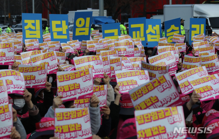 [서울=뉴시스] 김금보 기자 = 민주노총 서비스연맹 전국학교비정규직노동조합 조합원들이 지난달 25일 오후 서울 영등포구 여의대로에서 열린 '전국학교비정규직노동자 총파업대회'에서 손피켓을 들고 구로를 외치고 있다. 2022.12.05. kgb@newsis.com