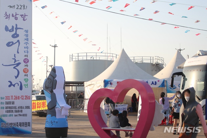 [제주=뉴시스] 양영전 기자 = 지난 26일 오후 제주 서귀포시 모슬포항 일원에서 열린 제22회 최남단 방어 축제를 찾은 한 가족이 사진을 찍고 있다. 2022.11.26. 0jeoni@newsis.com 