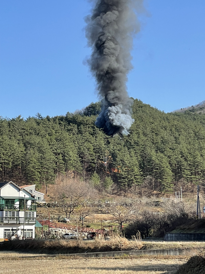 [양양=뉴시스] 김경목 기자 = 27일 오전 강원 양양군 현북면 어성전리 숲속에 산불 진화 임차용 민간 헬리콥터 1대가 추락하면서 검은 연기가 목격되고 있다. (사진=양양군청 제공) 2022.11.27. photo@newsis.com *재판매 및 DB 금지