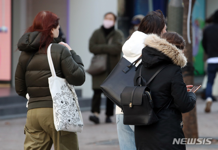 [서울=뉴시스] 고승민 기자 = 서울을 비롯한 중부지방 대부분 지역 최저기온이 영하권을 기록한 27일 서울 명동을 찾은 외국인 관광객과 시민이 두터운 옷을 입고 걸어가고 있다. 2022.11.27. kkssmm99@newsis.com