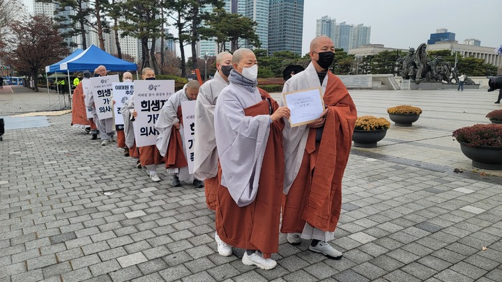[서울=뉴시스] 대한불교조계종 사회노동위원회가 28일 오후 용산 대통령 집무실 맞은편 전쟁기념관 앞에서 '이태원 참사 한 달, 희생자 추모와 희생자 가족 의견 존중 및 소통 공간 마련 촉구 기도회'를 진행하고 있다. (사진=대한불교조계종 사회노동위원회 제공) 2022.11.28. photo@newsis.com *재판매 및 DB 금지