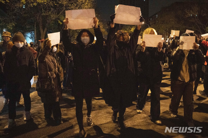 [베이징=AP/뉴시스] 27일 중국 베이징에서 코로나19 봉쇄 정책에 항의하는 시위대가 백지를 들고 구호를 외치고 있다. 고강도 방역 규제로 바이러스 전파를 막는 '제로 코로나' 조치에 분노한 시위대는 시진핑 중국 국가 주석의 퇴진을 요구했고 이는 최소 8개 도시에서 집권 공산당에 직접적으로 도전한 전례 없는 시위였다. 2022.11.28.<font _mstmutation="1" _msthash="178997" _msttexthash="395522127"></font>