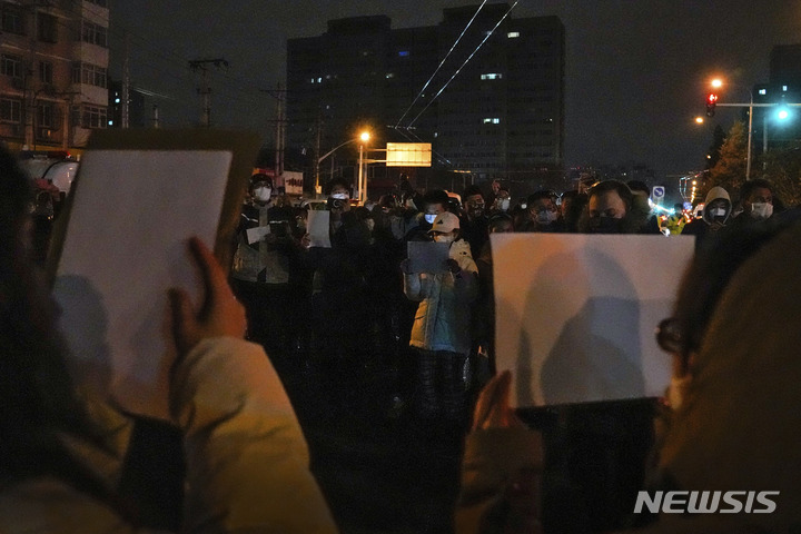 [베이징=AP/뉴시스] 27일 중국 베이징에서 코로나19 봉쇄 정책에 항의하는 시위대가 '백지'를 들고 구호를 외치고 있다. 시민들은 정부에 항의하는 의미를 담은 ‘백지’를 들고 28일 새벽까지 시위를 이어갔다. 2022.11.28.