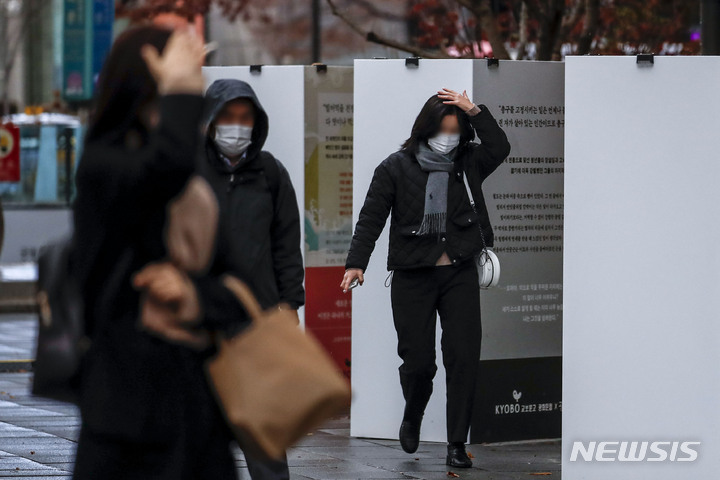 [서울=뉴시스] 정병혁 기자 = 28일 오전 서울 종로구 광화문광장에서 시민들이 머리를 손으로 가린 채 비를 피하고 있다. 2022.11.28. jhope@newsis.com