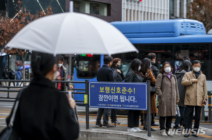 [서울=뉴시스] 정병혁 기자 = 28일 오전 서울 종로구 광화문네거리 인근에서 우산을 쓴 시민이 이동하고 있다. 2022.11.28. jhope@newsis.com
