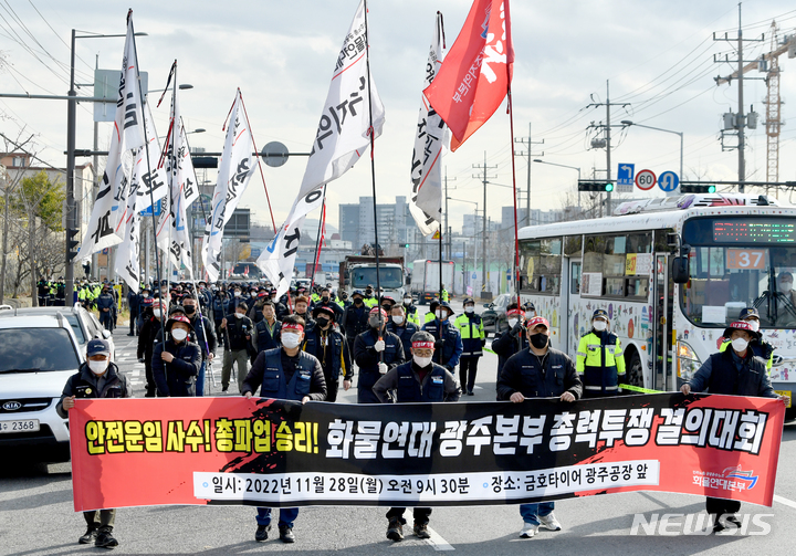 [광주=뉴시스] 김혜인 기자 = 민주노총 공공운수노조 화물연대 광주·전남 본부가 28일 오전 광주 광산구 소촌동 금호타이어 공장 앞에서  안전운임제 사수 결의대회'를 열고 도보행진을 하고 있다. 2022.11.28.hyein0342@newsis.com