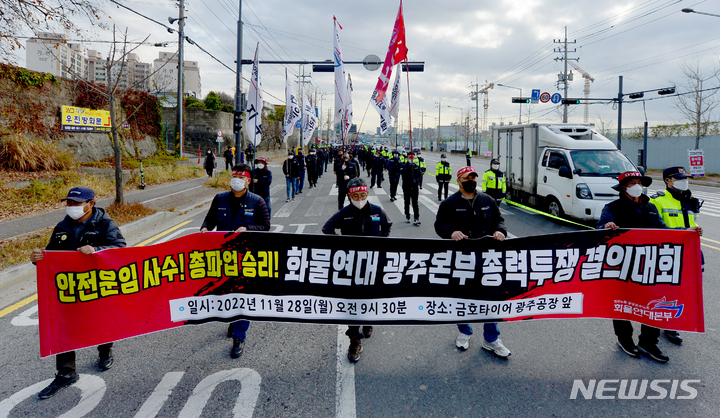 [광주=뉴시스] 김혜인 기자 = 민주노총 공공운수노조 화물연대 광주·전남 본부가 28일 오전 광주 광산구 소촌동 금호타이어 공장 앞에서 안전운임제 사수 결의대회'를 열고 도보행진을 하고 있다. 2022.11.28.hyein0342@newsis.com