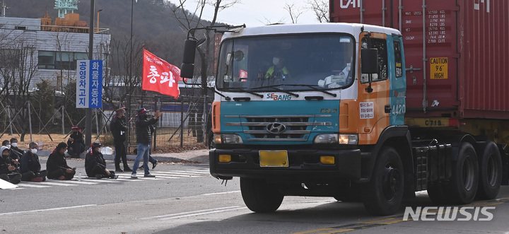 [의왕=뉴시스] 김종택 기자 = 민주노총 공공운수노조 화물연대 총파업 닷새째인 28일 경기도 의왕시 내륙컨테이너기지(ICD)에서 컨테이너를 실은  화물차가 경찰의 보호를 받으며 이동하고 있다. 2022.11.28. jtk@newsis.com