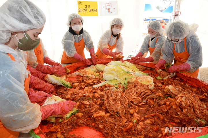 [울산=뉴시스] 배병수 기자 = 28일 울산대공원 남문광장에서 제19회 SK와 함께하는 행복김장 나눔행사가 열린 가운데 외국인 대학생들이 김장김치를 담그고 있다. 2022.11.28. bbs@newsis.com
