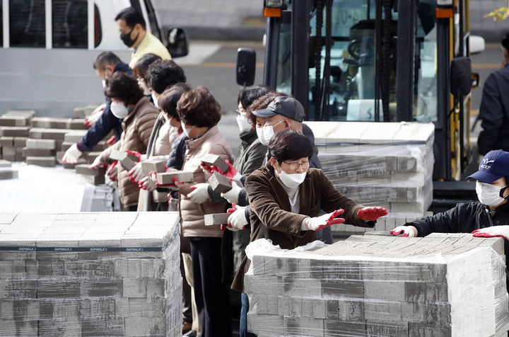 [광주=뉴시스] 변재훈 기자 = 광주 북구 문흥1동 직원과 통장들이 28일 북구 문흥1동 행정복지센터 주차장에서 열린 주민자치회 주관 물 절약 실천을 위한 양변기 수조 투입 벽돌 나눔 행사에서 지역 아파트 단지 11곳에 운반할 벽돌을 차량에 싣고 있다. (사진=광주 북구 제공) 2022.11.28. photo@newsis.com *재판매 및 DB 금지
